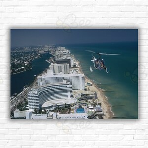 Slim Aarons Aerial Miami Beach Stampa/Poster - Un elicottero che trasporta turisti volteggia sopra il Fontainebleau Hotel a Miami Beach, Florida