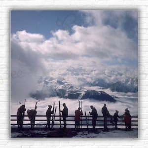 Slim Aarons Verbier Visualizza stampa/poster - Gli sciatori ammirano la vista su una valle di nuvole a Verbier, 1964.