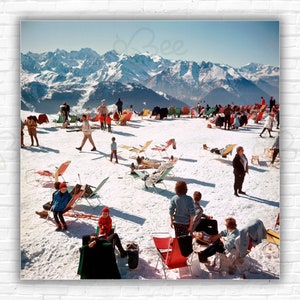 Stampa/manifesto delle vacanze di Slim Aarons a Verbier: vacanzieri prendono il sole sulla cima di una montagna a Verbier, 1964.