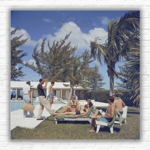 Slim Aarons At Lyford Cay Stampa/Poster - Ospiti che prendono il sole a bordo piscina al Lyford Cay Club, New Providence Island, Bahamas
