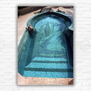 Stampa/poster di Slim Aarons Moroccan Pool: bagnanti presso una piscina a forma di arco rivestita di mosaico a Marrakech, Marocco, aprile 1988.