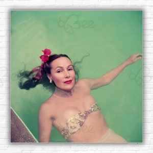 Stampa/Manifesto di Slim Aarons Dolores Del Rio - La star del cinema messicano Dolores Del Rio (1905 - 1983) galleggia in una piscina ad Acapulco, 1952.