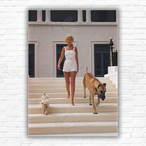 Slim Aarons C.Z. Guest Print/Poster - C.Z. Guest con un barboncino e un alano nella sua tenuta di fronte all'oceano, Villa Artemis, Palm Beach, Florida