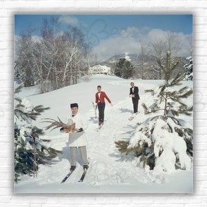 Impressão/pôster Slim Aarons Skiing Waiters - Três garçons esquiadores com pássaro, vinho e menu em uma encosta em Stowe, Vermont