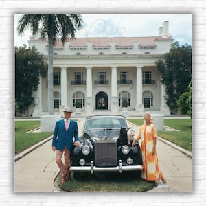 Stampa/Poster di Slim Aarons Donald Leas - Il signor e la signora Donald Leas con la Rolls Royce e i cani fuori dal Flagler Museum, Palm Beach, Florida