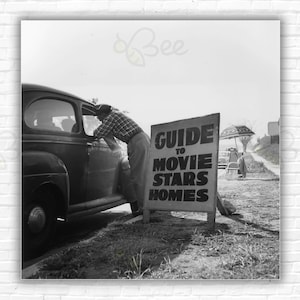 Póster/impresión de fans curiosos de Slim Aarons: un hombre le vende a un conductor un mapa con la ubicación de las casas de las estrellas de cine. Un cartel dice: Guía de casas de estrellas de cine