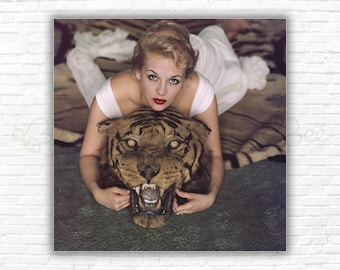 Slim Aarons Beauty & The Beast Print/Poster: Daphne Cameron on tiger skin rug in trophy room at Laddie Sanford's home Palm Beach Florida