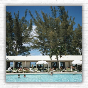 Stampa/poster Slim Aarons Lyford Cay Club - Ospiti che prendono il sole a bordo piscina al Lyford Cay Club, New Providence Island, Bahamas