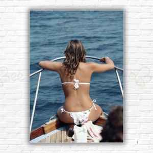 Slim Aarons Amalfi Coast Print/Poster - Woman in bikini sitting on boat prow, looking over water on the Amalfi Coast, Italy, 1984.