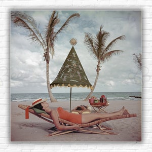 Stampa/poster "Palm Beach Idyll" di Slim Aarons: una coppia prende il sole in riva al mare a Palm Beach, Florida, circa 1955.
