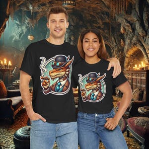 May include: Two black t-shirts with a graphic print of a dragon wearing a bowler hat and goggles. The dragon is holding a cigar and has a smoke coming from its mouth. The dragon is wearing a suit and tie.