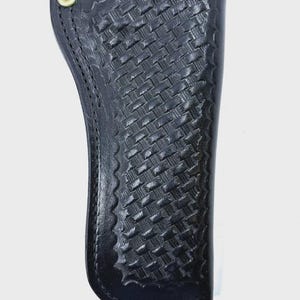 Peut inclure: Un &eacute;tui en cuir noir avec un motif de tissage en panier. L'&eacute;tui a un bord festonn&eacute; et un rivet de couleur laiton. La conception est pour une arme &agrave; feu.