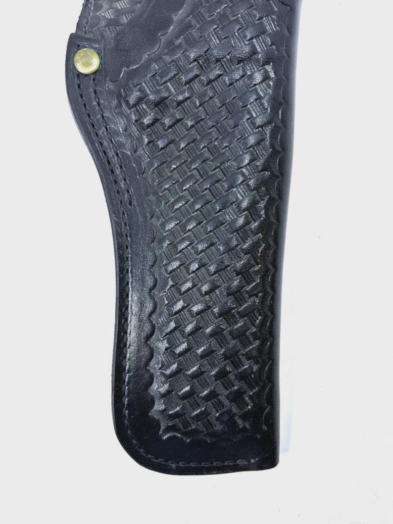Peut inclure: Un &eacute;tui en cuir noir avec un motif de tissage en panier. L'&eacute;tui a un bord festonn&eacute; et un rivet de couleur laiton. La conception est pour une arme &agrave; feu.