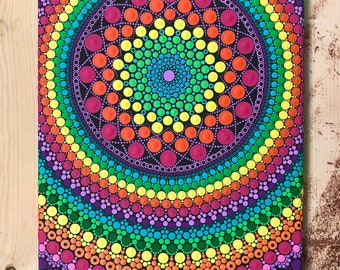 May include: A colorful mandala design painted on a canvas using the dot painting technique. The mandala features a rainbow of colors, including red, orange, yellow, green, blue, indigo, and violet. The dots are arranged in concentric circles, creating a visually appealing and intricate pattern.