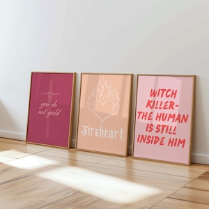 Könnte beinhalten: Drei gerahmte Kunstdrucke mit inspirierenden Zitaten. Der erste Druck ist weinrot mit einer Schwertillustration und dem Text "you do not yield". Der zweite Druck ist pfirsichfarben mit einem Herzen in Flammen und dem Wort "Fireheart". Der dritte Druck ist rosa mit dem Text "Witch Killer - The Human Is Still Inside Him."