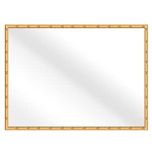 May include: A rectangular mirror with a natural wood frame. The frame is made of thin strips of wood that are arranged in a grid pattern. The mirror is surrounded by a thin, gold-colored border.