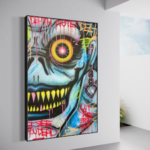 May include: Framed graffiti art depicting a blue-skinned face with a large, yellow and red eye. The artwork includes sharp yellow teeth, dripping red paint, and the words "DEATH NOTE" and "YOU DEAD" in graffiti style.
