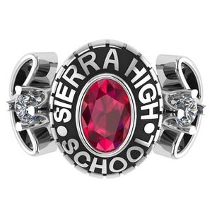 May include: A silver class ring with a black and white inscription that reads "Sierra High School". The ring features a red oval gemstone.