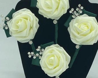 May include: Four ivory foam rose boutonnieres with green satin ribbon and silver rhinestone accents.