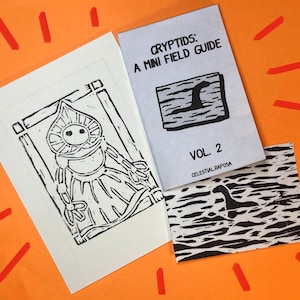 Może przedstawiać: Pomarańczowe tło z trzema wydrukowanymi elementami. Biała karta z czarno-białą ilustracją postaci. Broszura zatytułowana "CRYPTIDS: A MINI FIELD GUIDE" z ilustracją Nessie. Karta z ilustracją Nessie.