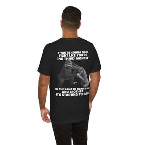 May include: Black t-shirt with a graphic of two gorillas fighting, and text that reads "IF YOU'RE GONNA FIGHT FIGHT LIKE YOU'RE THE THIRD MONKEY ON THE RAMP TO NOAH'S ARK AND BROTHER IT'S STARTING TO RAIN."