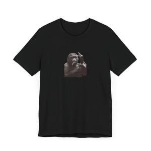 May include: Black t-shirt with a graphic of a gorilla smoking a cigarette and giving the middle finger.