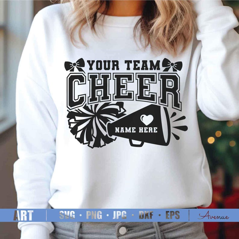 K&ouml;nnte beinhalten: Wei&szlig;es Sweatshirt mit einem schwarzen Grafikdesign. Das Design enth&auml;lt die Worte "YOUR TEAM CHEER" &uuml;ber einer Megaphon und einem Pompon. Das Megaphon hat ein Herz und die Worte "NAME HERE".