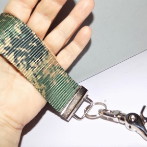 May include: A camouflage patterned key chain with a silver swivel clasp and a silver ring.
