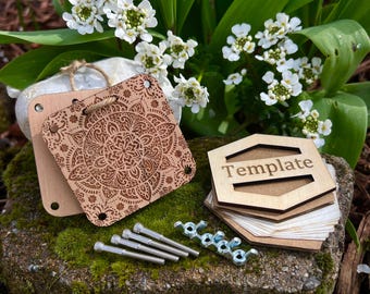 Puede incluir: Suministros de artesanía de madera que incluyen un posavasos cuadrado con un diseño de mandala, una pila de plantillas hexagonales con la palabra "Template" y herrajes metálicos. Los artículos están dispuestos sobre una roca musgosa con flores blancas en el fondo.