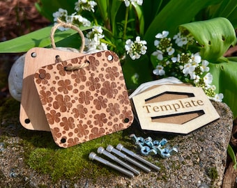 Puede incluir: Dos placas de madera con un patrón de trébol y la palabra "Plantilla" en una placa hexagonal. Las placas están rodeadas de pequeños tornillos y tuercas de metal.