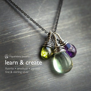 May include: A silver chain necklace with a pendant featuring three teardrop-shaped gemstones: a green fluorite, a light green peridot, and a purple amethyst. The gemstones are wrapped in silver wire.