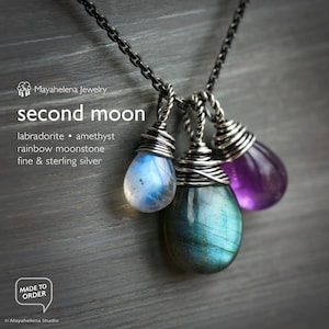 May include: A silver necklace with three teardrop-shaped pendants. The pendants are made of labradorite, amethyst, and rainbow moonstone. The necklace is made of fine and sterling silver.