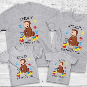 May include: A set of four gray t-shirts with a Curious George graphic. Each shirt has a different name: Daddy, Mommy, Sister, and Olivia. The shirts also feature the text "3 of the Birthday Girl".