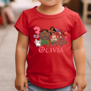 以下が含まれることがあります： 人気アニメのキャラクターが描かれた、鮮やかなグラフィックの赤いTシャツ。3の数字と「Olivia」という名前も表示されています。Tシャツは小さな子供が着ています。