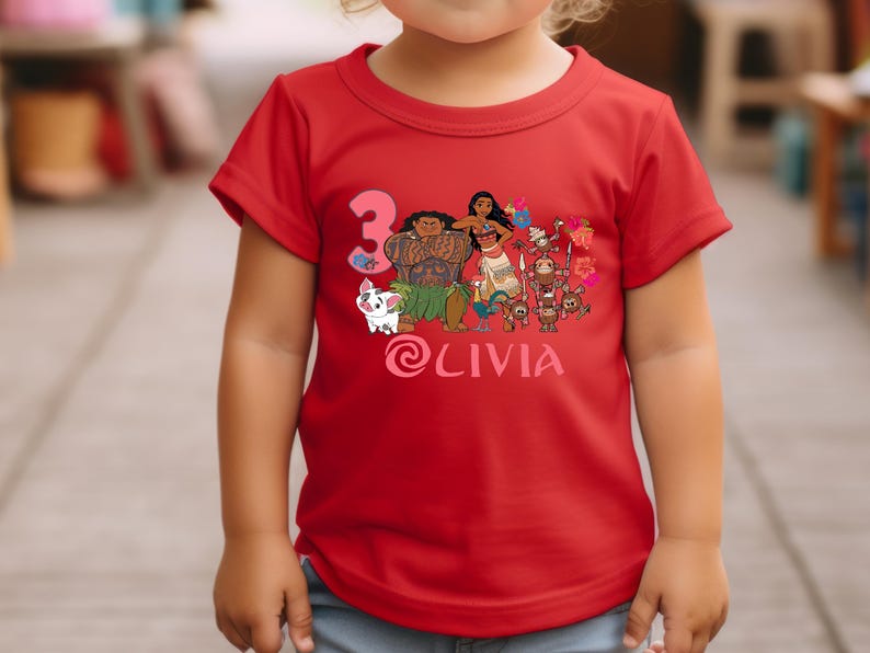 以下が含まれることがあります： 人気アニメのキャラクターが描かれた、鮮やかなグラフィックの赤いTシャツ。3の数字と「Olivia」という名前も表示されています。Tシャツは小さな子供が着ています。