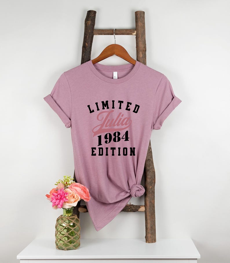 May include: A mauve t-shirt with the text "LIMITED Julia 1984 EDITION" printed on it.
