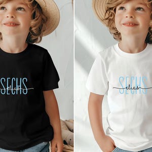 Peut inclure: Deux enfants portant des t-shirts noir et blanc avec le texte "SECHS Elias" en lettres bleues.