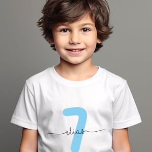 May include: A white t-shirt with a blue number seven and the name "Elias" written underneath.