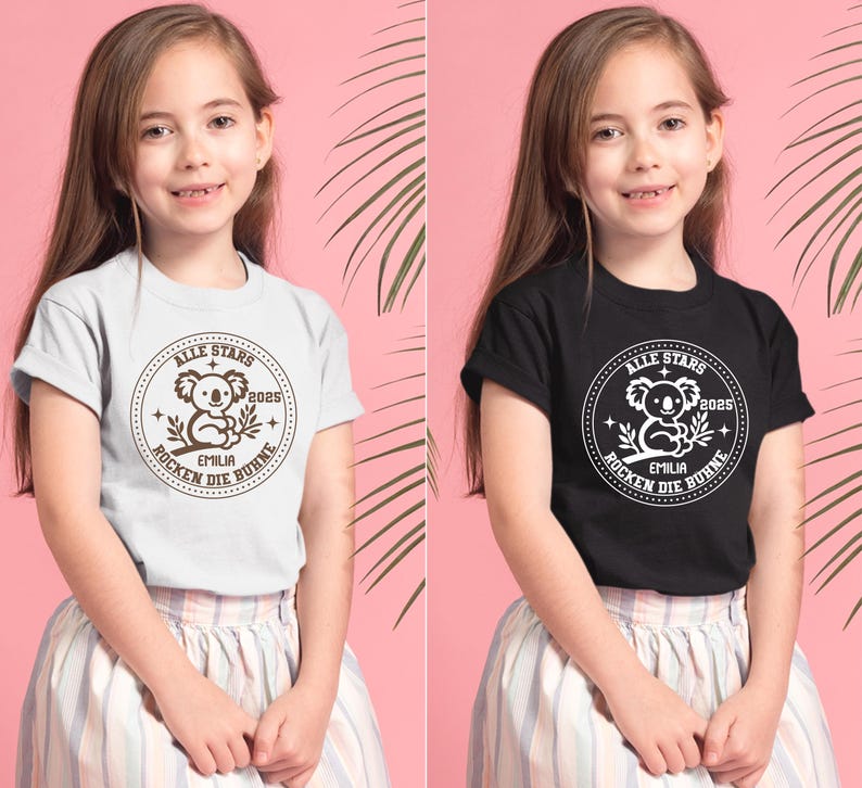 May include: Two children wearing t-shirts with a brown koala graphic and the text "ALLE STARS 2025 EMILIA ROCKEN DIE B&Uuml;HNE" in a circle. The girl on the left is wearing a light gray t-shirt and the girl on the right is wearing a black t-shirt.