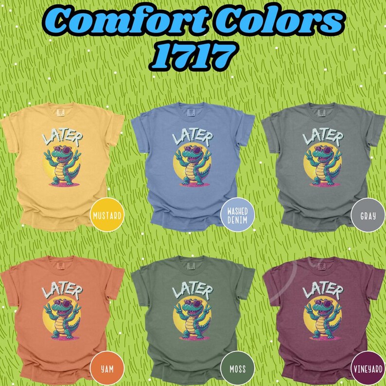 May include: Six t-shirts in different colors with a cartoon alligator wearing sunglasses and the word "LATER" printed on them. The colors are mustard, washed denim, gray, yam, moss, and vineyard.