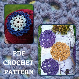 Puede incluir: Patrón de crochet PDF para un motivo de flor. El patrón incluye instrucciones para tejer una flor con un centro azul y pétalos blancos. La imagen también muestra tres flores tejidas a crochet en morado y dorado.