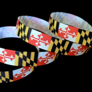 May include: A roll of black, yellow, red, and white ribbon with the Maryland state flag printed on it.