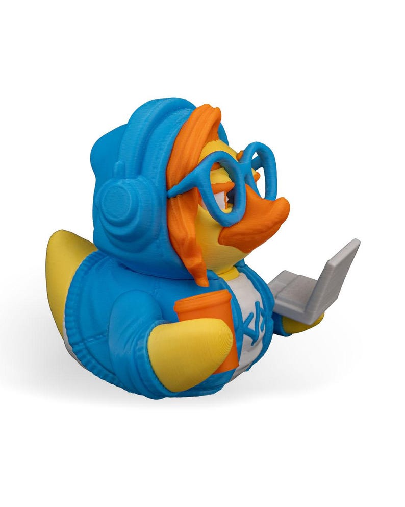 May include: A blue rubber duck wearing headphones, glasses, and a blue hoodie, holding a cup and a laptop.