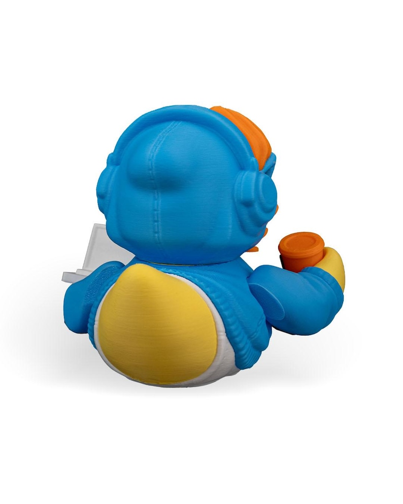 May include: A blue rubber duck wearing a blue hoodie with a white zipper and orange headphones. The duck is holding a white laptop and a cup of coffee in its right hand.