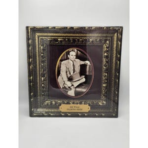 May include: A framed sepia-toned photograph of a man seated, holding a hat, within an oval frame. The frame is ornate, dark with gold accents. The text "BOB WILLS COLLECTOR SERIES" is displayed on a small plaque.