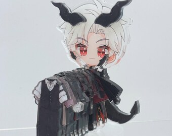 May include: A clear acrylic charm featuring a chibi-style anime character with white hair, red eyes, and black horns. The character is wearing a black outfit with red accents. The charm is standing on a clear base.