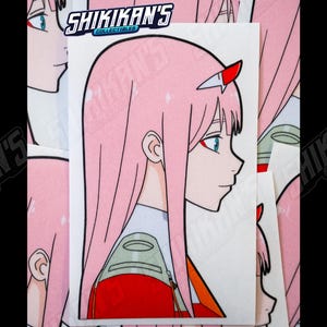 May include: A white sticker featuring a side profile of an anime character with pink hair and red horns. The sticker is 5 inches in height. The sticker has the text "SHIKIKAN'S COLLECTIBLES".