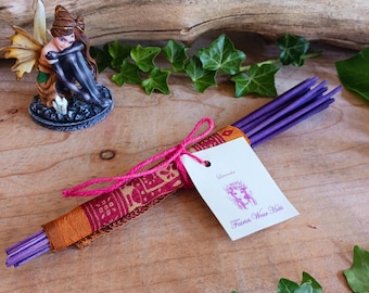 May include: A bundle of purple incense sticks wrapped in a colorful fabric with a tag that reads "Lavender" and "Fairies Weave Hairs".