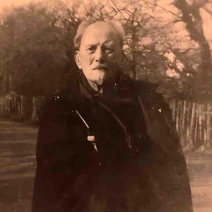 May include: Sepia-toned photograph of an older man with white hair and a mustache, wearing a dark coat. The image includes the text "The Crowley Collection" at the bottom, suggesting a historical or vintage theme.