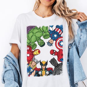 A woman wearing a white t-shirt with a graphic of various Marvel superheroes, including Hulk, Captain America, Iron Man, Spider-Man, and others, arranged in a circular pattern.